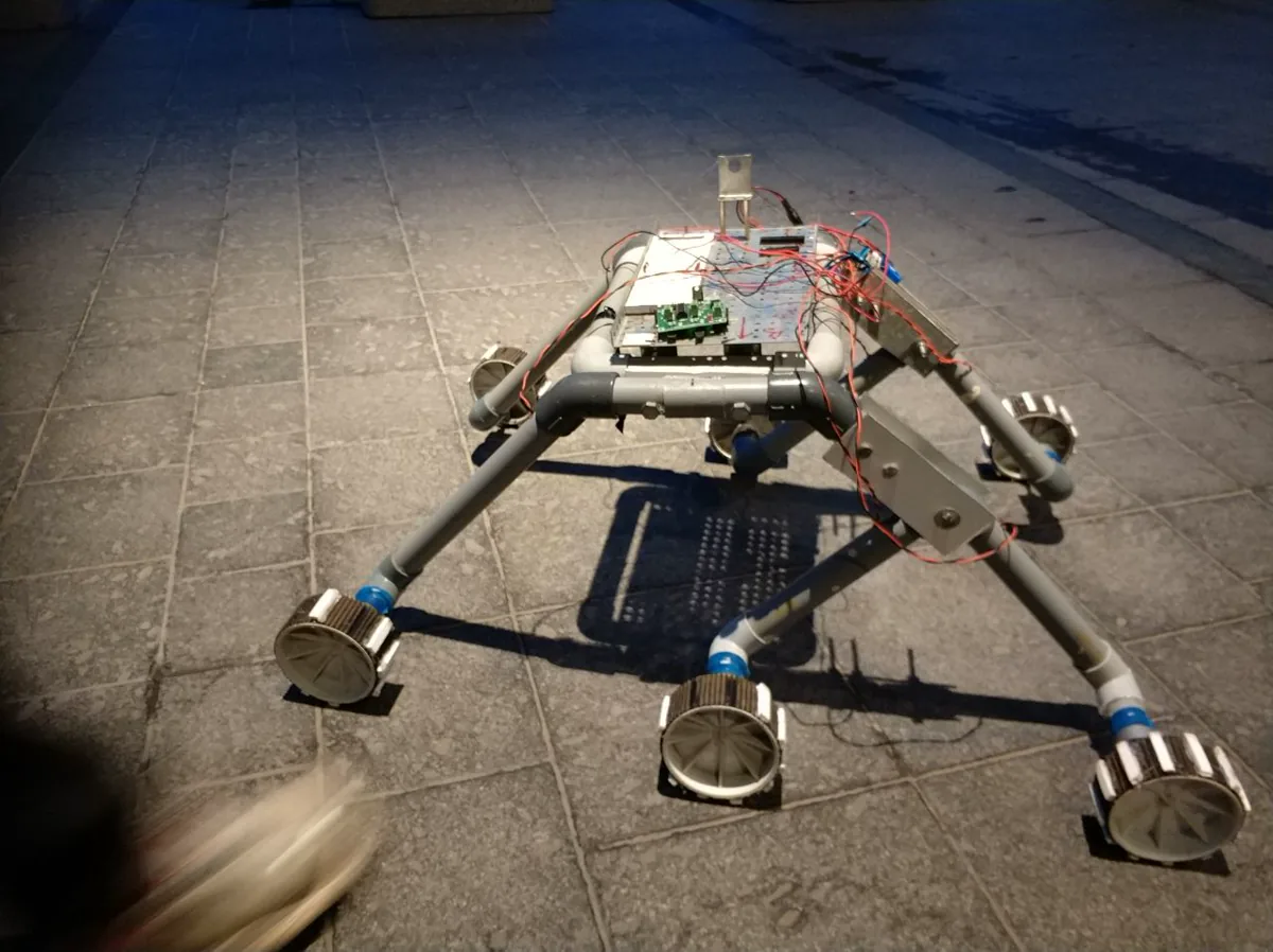 Staircase-climbing wheelchair prototype with robotic arm.